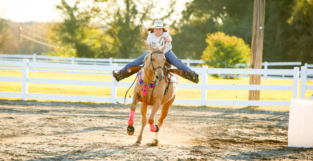 Ella Nipper riding her palomino horse, running fast.